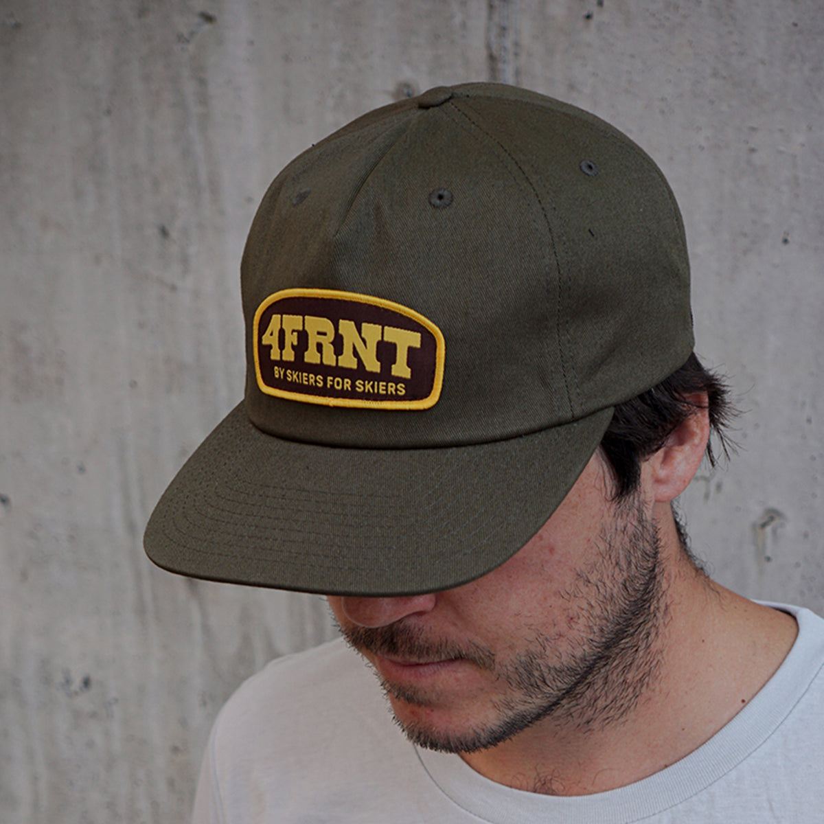 dark green hat with rodeo 4frnt logo on a man with dark hair and short beard in a white shirt